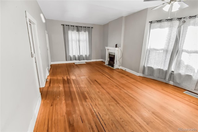 unfurnished living room with ceiling fan and hardwood / wood-style floors