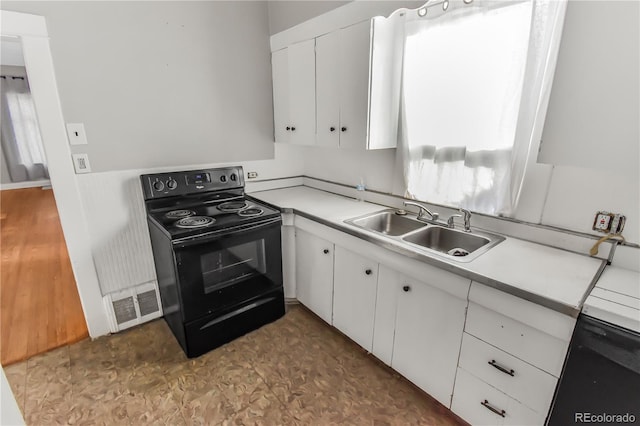 kitchen with sink, white cabinetry, and black electric range oven