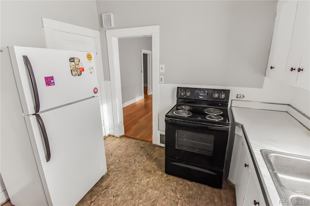 kitchen featuring sink, white cabinets, white refrigerator, and black range with electric cooktop