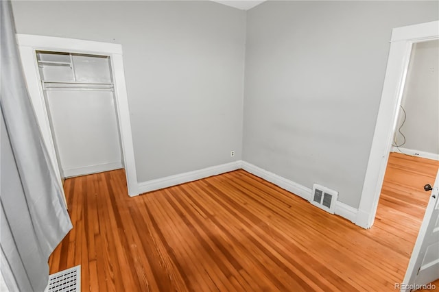 unfurnished bedroom with a closet and hardwood / wood-style flooring