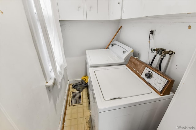 laundry area with washer and clothes dryer and cabinets