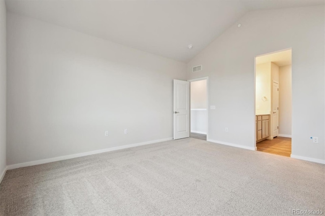 1321 Loraine Cir N, Lafayette, CO 80026 - unfurnished bedroom with high vaulted ceiling, connected bathroom, light carpet, visible vents, and baseboards