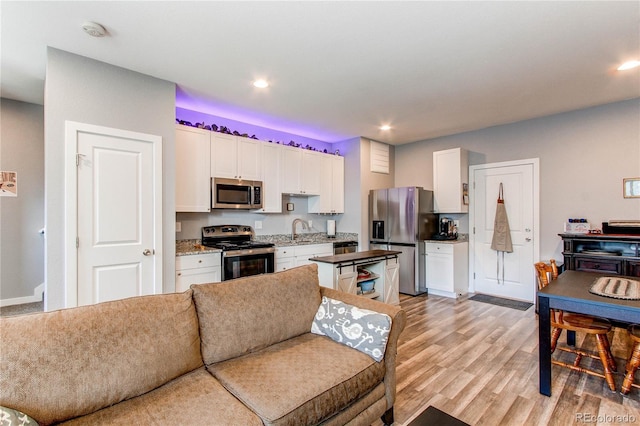262 S 4th Ct, Deer Trail, CO 80105 - kitchen featuring stainless steel appliances, white cabinets, light wood-type flooring, open floor plan, and recessed lighting