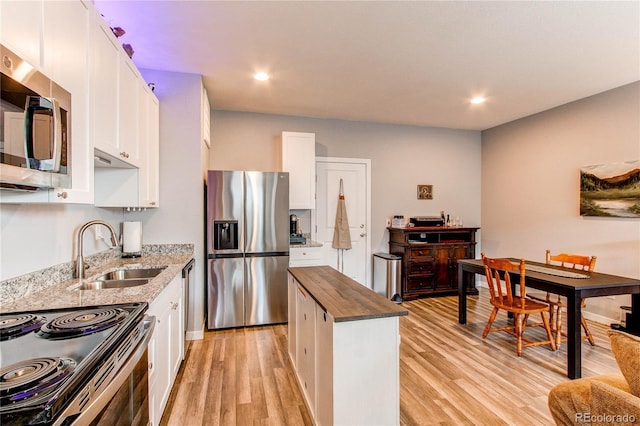 262 S 4th Ct, Deer Trail, CO 80105 - kitchen featuring stainless steel appliances, white cabinetry, light wood-style flooring, butcher block countertops, and a center island