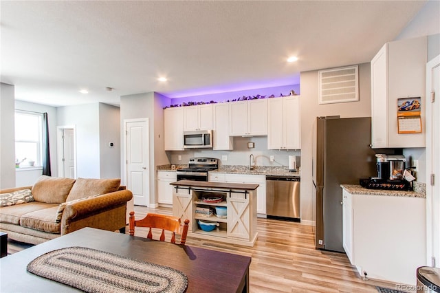 262 S 4th Ct, Deer Trail, CO 80105 - kitchen with stainless steel appliances, white cabinetry, light wood-style flooring, recessed lighting, and light stone counters