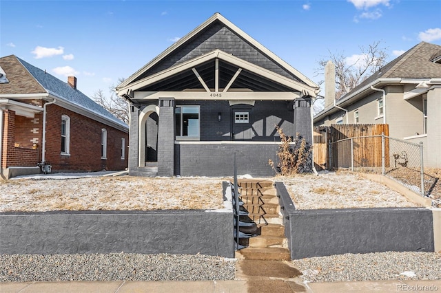 view of front of house featuring brick siding and fence