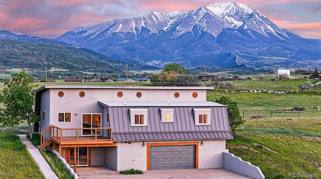 exterior space with a garage, a mountain view, and a yard