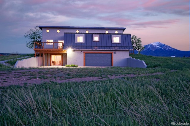 view of front of house with a garage, a mountain view, and a balcony