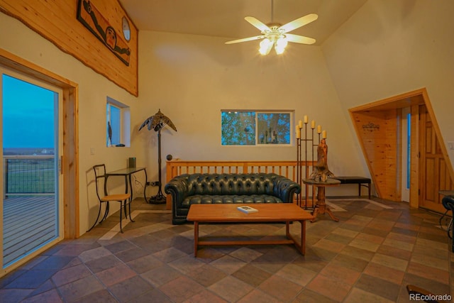 living room featuring high vaulted ceiling, ceiling fan, and dark tile floors