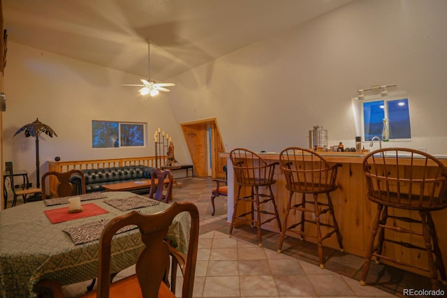 dining space with vaulted ceiling, ceiling fan, and light tile floors