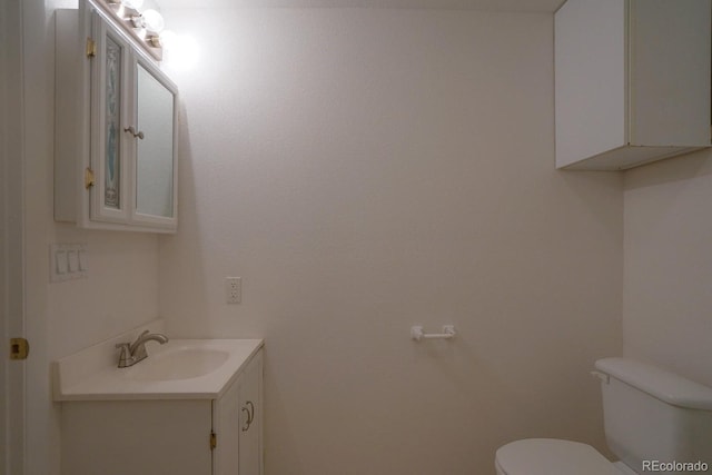 bathroom with toilet and large vanity