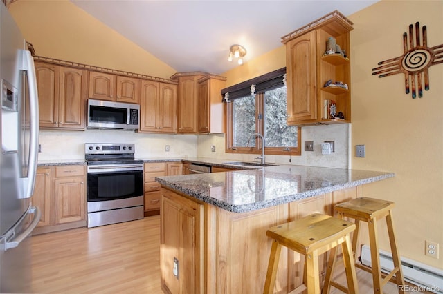 kitchen featuring stainless steel appliances, kitchen peninsula, sink, and stone countertops