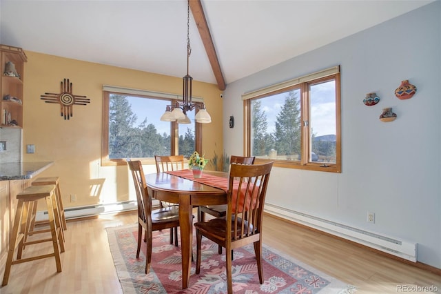 dining space featuring a wealth of natural light, light wood-type flooring, and a baseboard heating unit