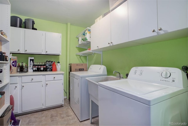 clothes washing area featuring cabinets and washing machine and clothes dryer