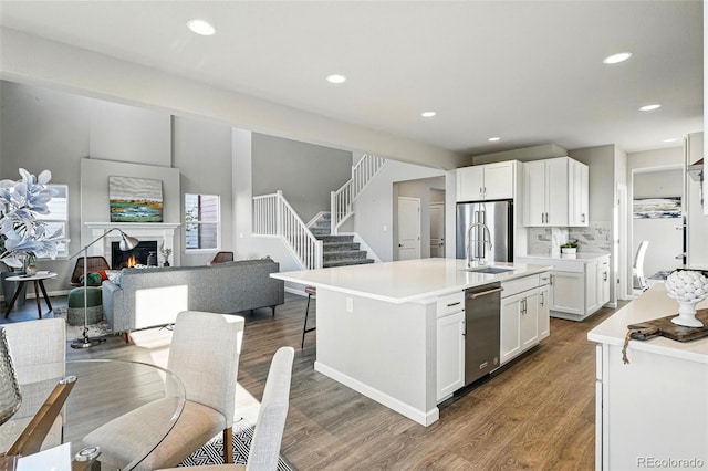 kitchen with stainless steel appliances, recessed lighting, dark wood-style flooring, open floor plan, and white cabinets