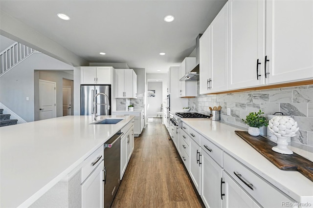 kitchen with a sink, stainless steel appliances, light countertops, and white cabinets