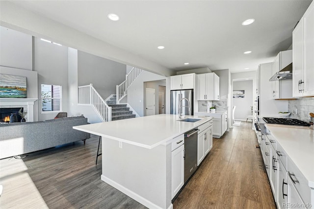 kitchen featuring dark wood finished floors, tasteful backsplash, light countertops, and appliances with stainless steel finishes