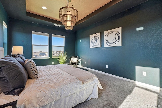 carpeted bedroom featuring visible vents, recessed lighting, an inviting chandelier, a tray ceiling, and baseboards