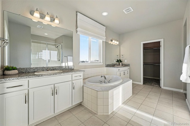 bathroom with a sink, a stall shower, visible vents, and tile patterned floors