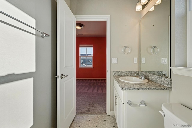 bathroom featuring toilet, baseboards, and vanity
