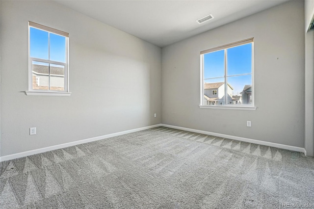 carpeted empty room with baseboards and visible vents