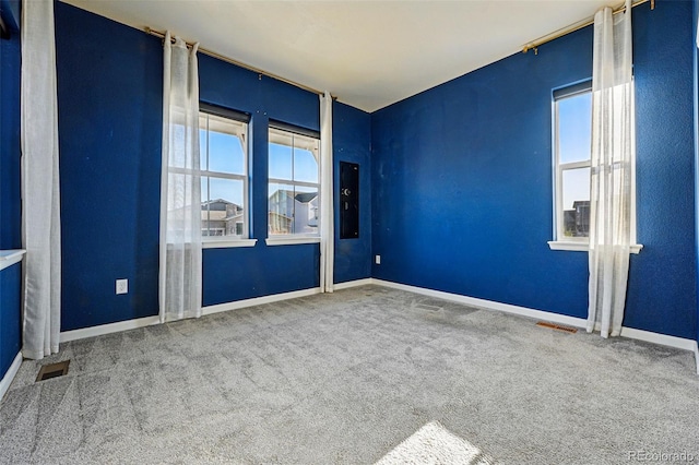 carpeted empty room featuring baseboards and visible vents