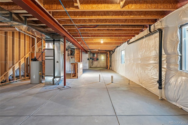 basement with a healthy amount of sunlight and water heater