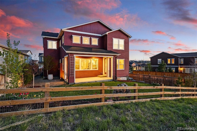 view of front of house featuring a fenced front yard and a lawn