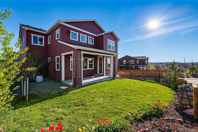rear view of property with a yard, fence, and a patio area