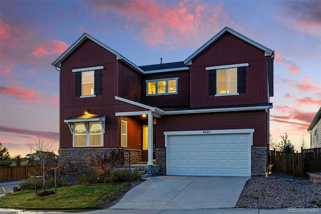 traditional home featuring stone siding, driveway, fence, and a garage