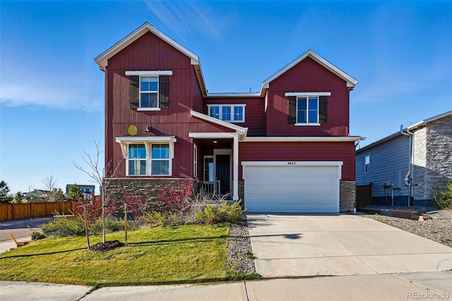view of front of property with a front lawn, stone siding, a garage, and driveway