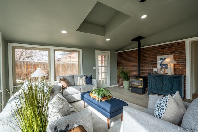 living area with lofted ceiling, wood finished floors, a wood stove, and recessed lighting