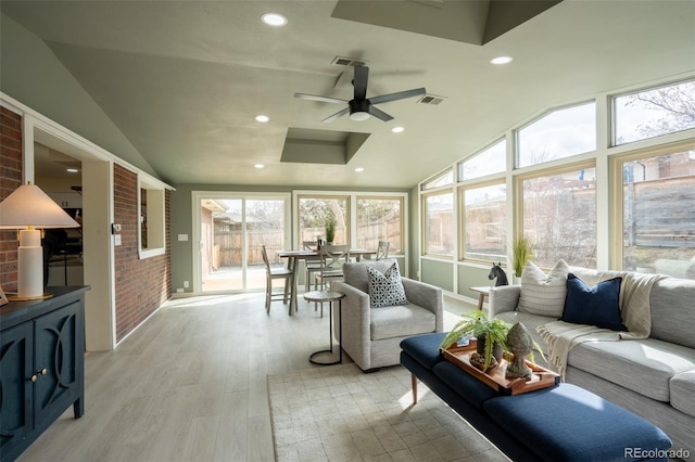 sunroom / solarium featuring lofted ceiling, visible vents, and a ceiling fan