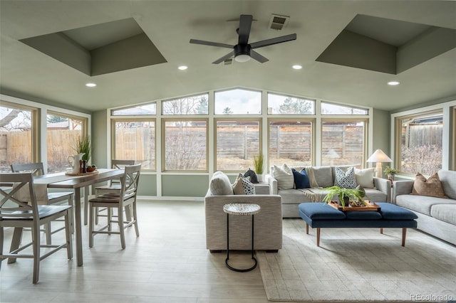 sunroom / solarium with lofted ceiling, visible vents, and ceiling fan