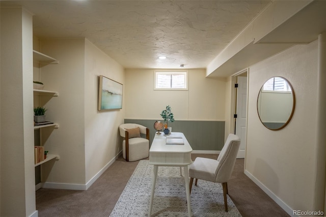 carpeted office space featuring a textured ceiling and baseboards