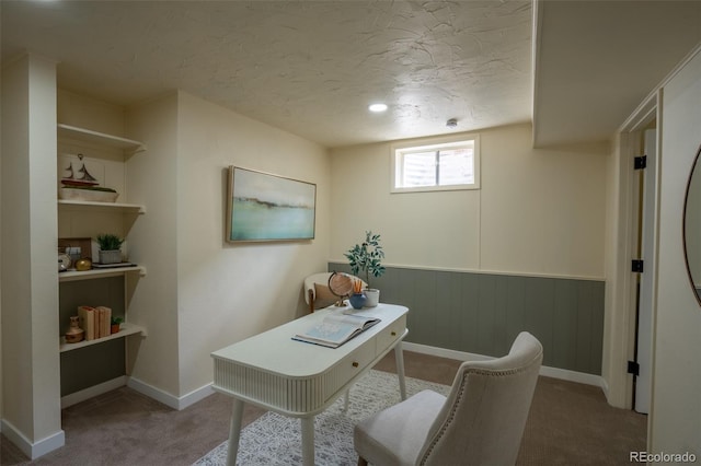 carpeted home office featuring a textured ceiling and baseboards