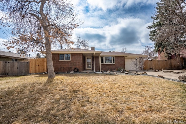 ranch-style home featuring a front yard, brick siding, fence, and an attached garage