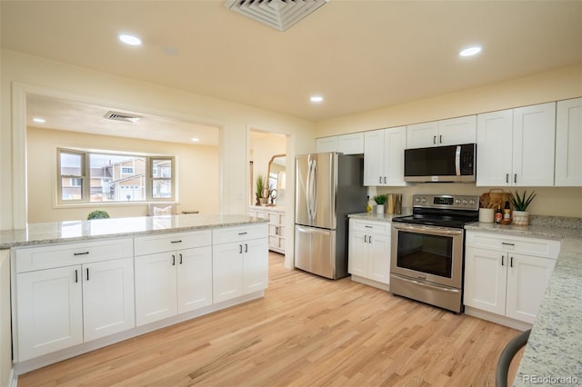 kitchen with stainless steel appliances, recessed lighting, white cabinetry, and light wood finished floors