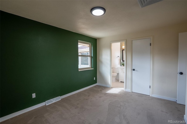 unfurnished bedroom with carpet, visible vents, and baseboards