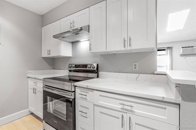 381 S Ames St Unit E305, Lakewood, CO 80226 - kitchen with electric range, white cabinets, under cabinet range hood, and light wood-style flooring