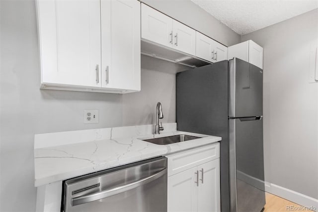 381 S Ames St Unit E305, Lakewood, CO 80226 - kitchen with light stone countertops, white cabinetry, stainless steel appliances, and a sink