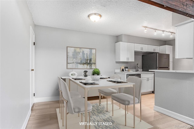 381 S Ames St Unit E305, Lakewood, CO 80226 - dining room featuring baseboards, a textured ceiling, and light wood finished floors