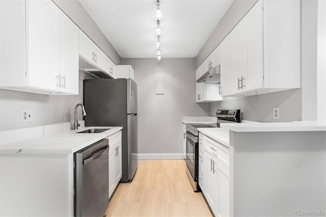381 S Ames St Unit E305, Lakewood, CO 80226 - kitchen with white cabinets, stainless steel appliances, a sink, light wood-style floors, and rail lighting
