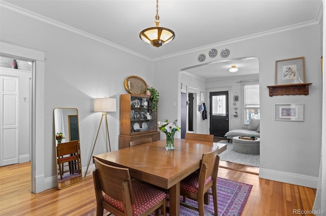 dining space featuring ornamental molding and light hardwood / wood-style floors