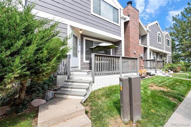 view of exterior entry with a lawn