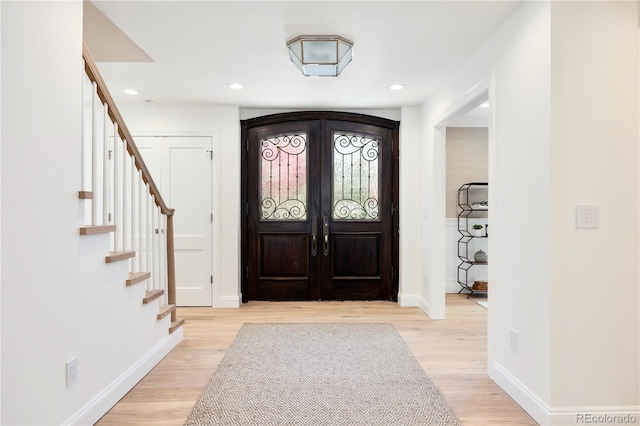 foyer with recessed lighting, baseboards, and light wood-style flooring