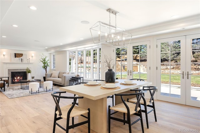 dining space with a wealth of natural light, crown molding, and french doors