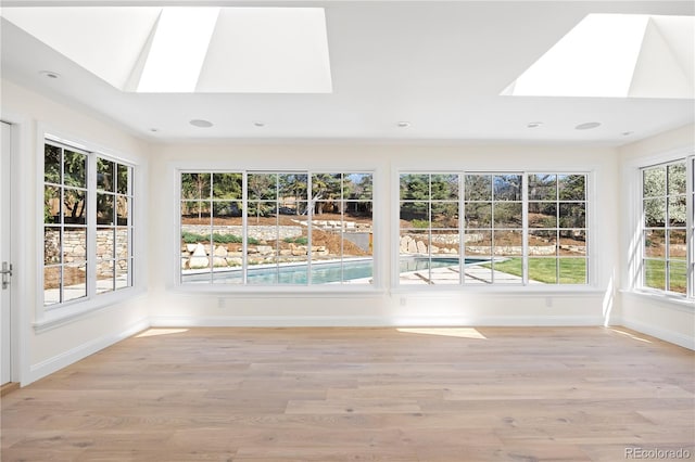unfurnished sunroom with a skylight