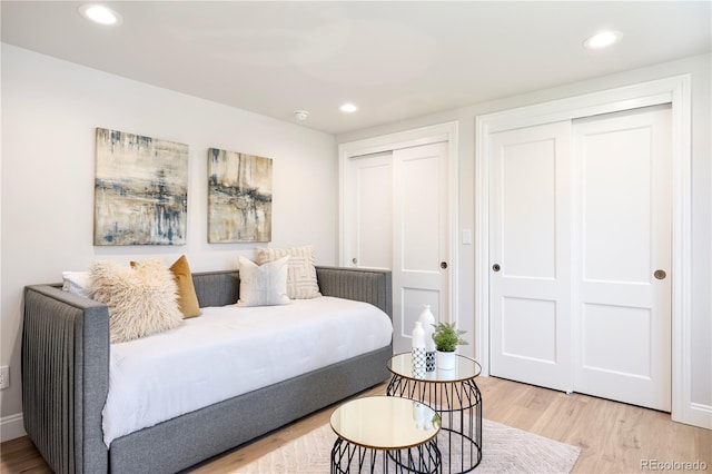 bedroom with multiple closets, wood finished floors, and recessed lighting
