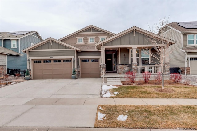 craftsman inspired home featuring a porch, a garage, and a front lawn